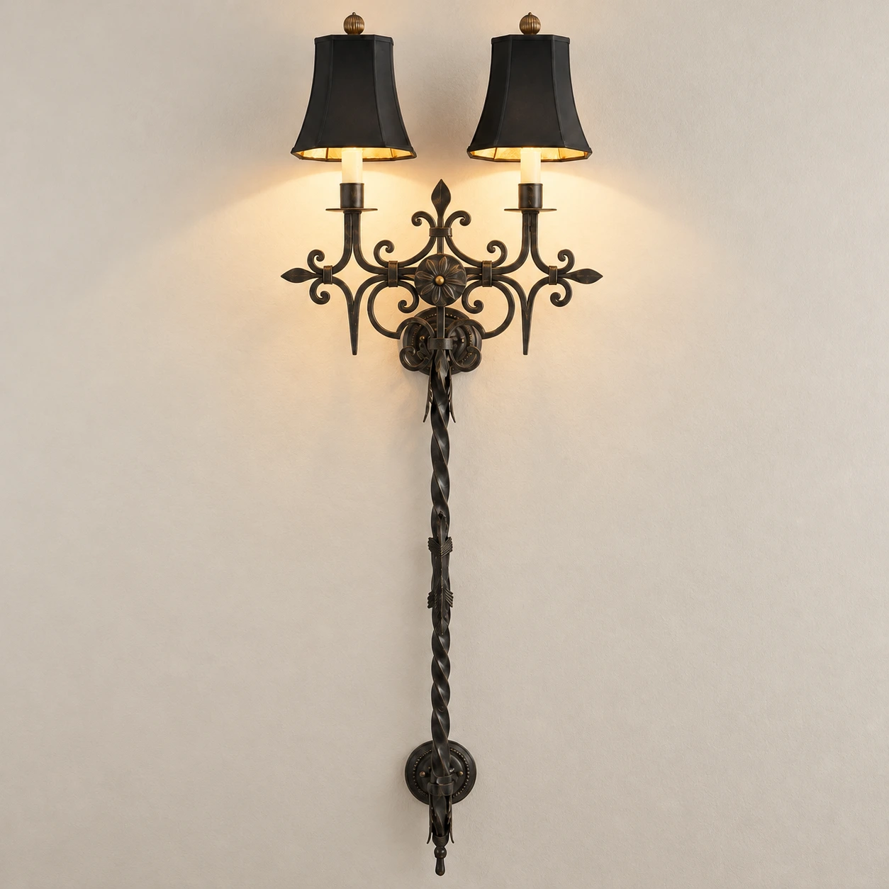Black distressed iron wall sconce illuminated in a neutral studio