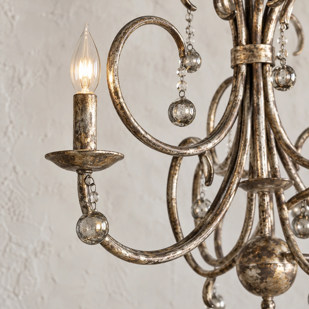 Close detail of aged iron candle cup, curled arm and clear crystal drops