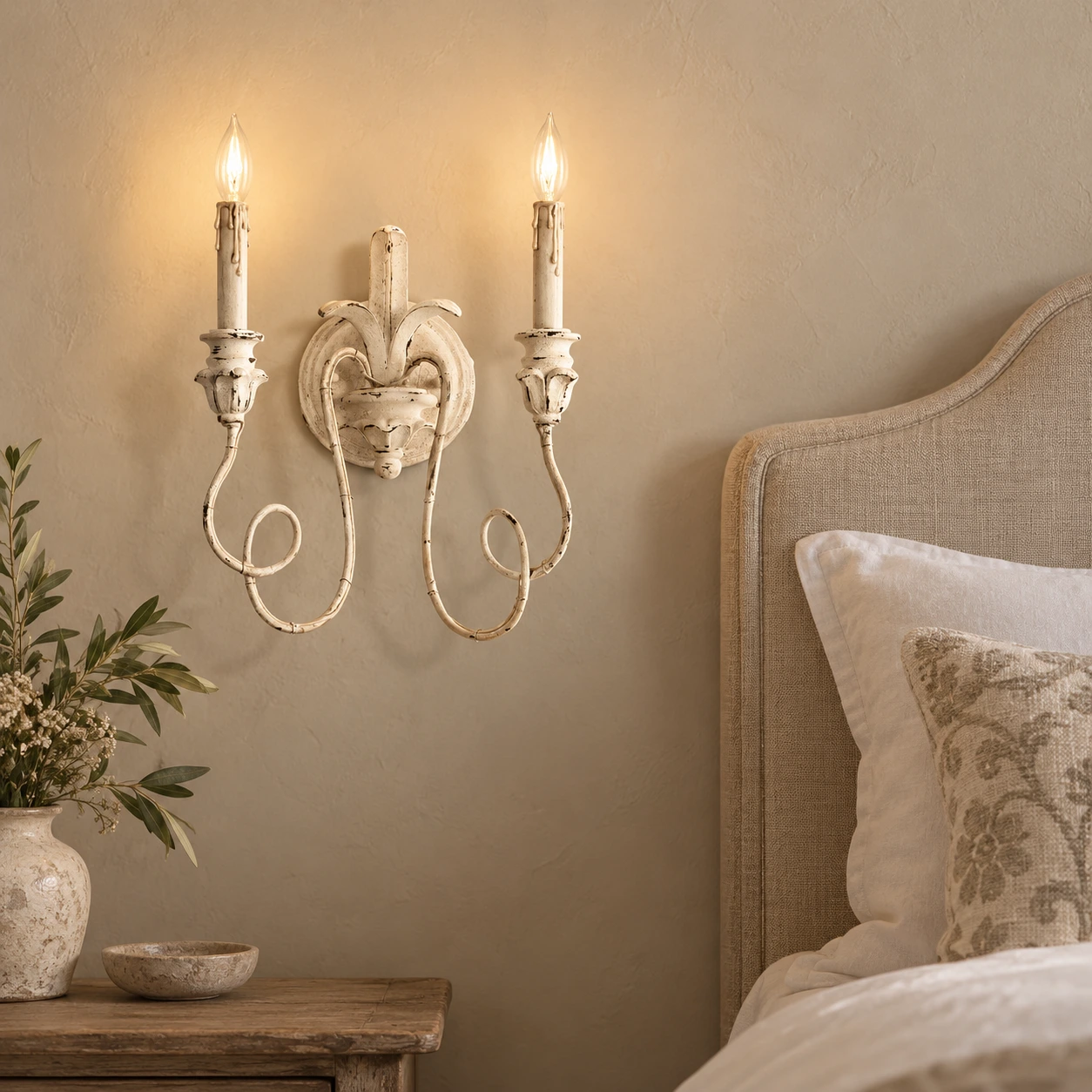 Cassia white aged wall sconce beside a linen headboard